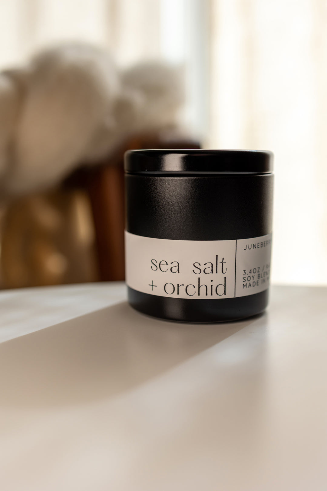 Sea Salt and Orchid Soy Candle in matte black vessel by juneberryplace home fragrances
